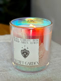 Aromatherapy candle labeled "Secret Garden" by Astraea Fragrance Haus in a glass jar with floral design.