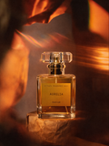 Aurelia perfume bottle by Astraea Fragrance Haus with elegant glass design and silver cap, displayed on a neutral background.