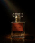 Astraea Fragrance Haus Holy Grail perfume bottle with elegant design and gold accents on a reflective surface.