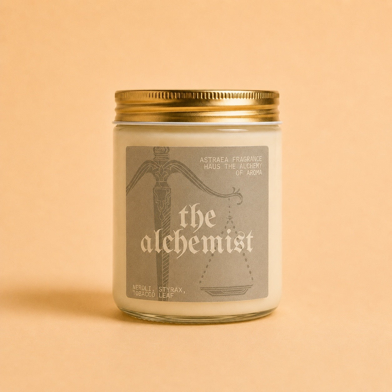 A bottle of Astraea Fragrance Haus "The Alchemist" perfume with a sleek glass design and minimalist label on a neutral background.
