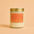 A close-up of the Just Peachy fragrance bottle by Astraea Fragrance Haus with a peach-themed design.