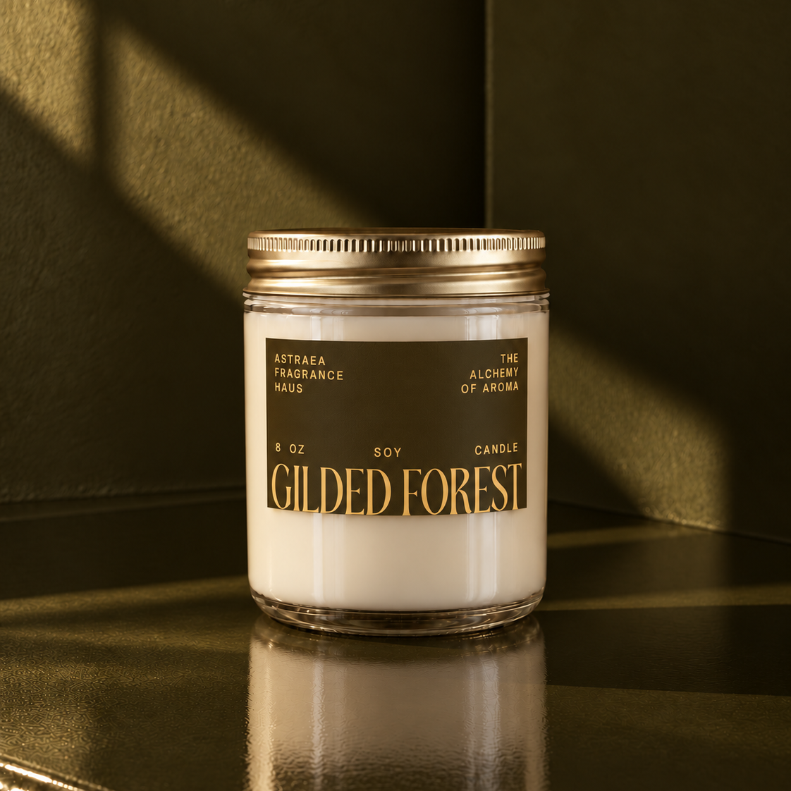 Soy candle in a clear glass jar with a gold lid, labeled "Gilded Forest" by Astraea Fragrance Haus, placed on a dark surface.
