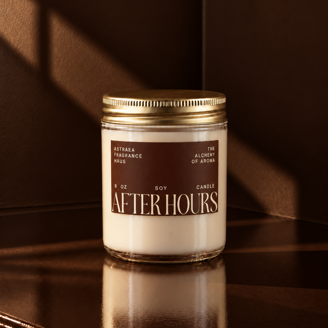 Soy candle labeled "After Hours" by Astraea Fragrance Haus in a clear glass jar with a gold lid, placed on a wooden surface.